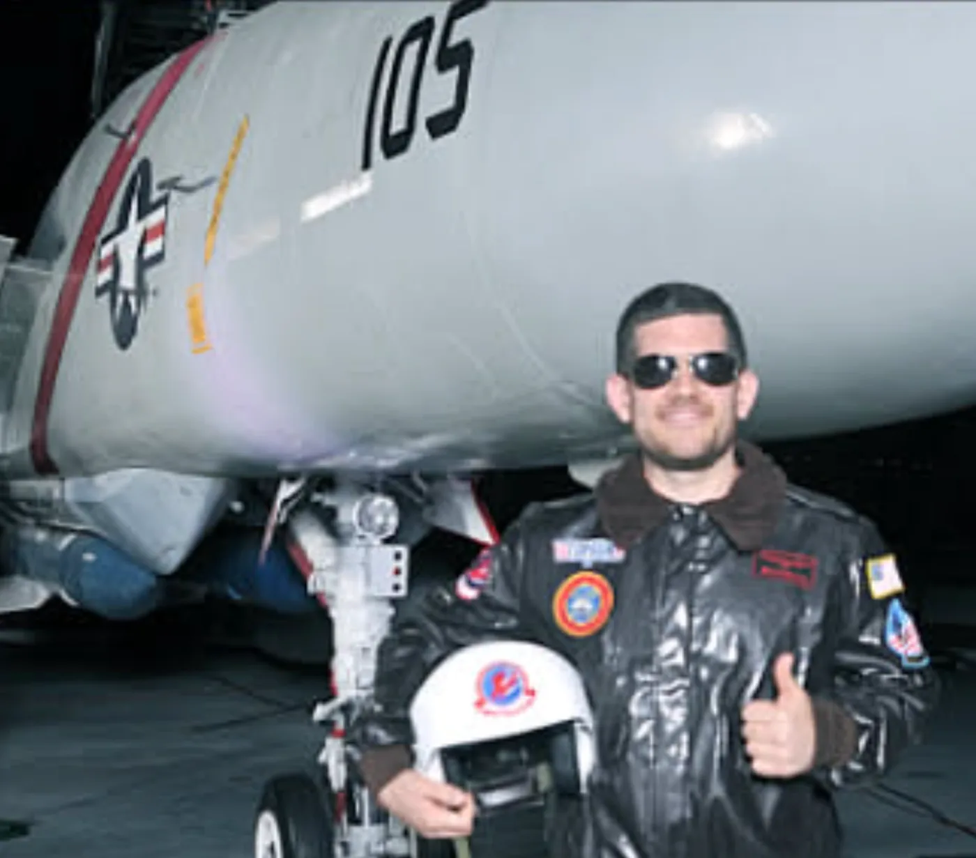 Matthew Brahms in a flight suit beside an F-14 Tomcat